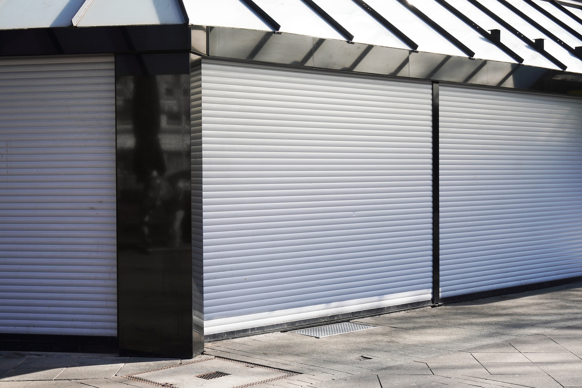 closed business shop or store front with roller shutters. economy crisis and recession concept.